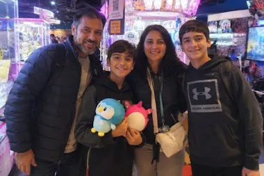 Family holding prize plushies won at an Akihabara arcade