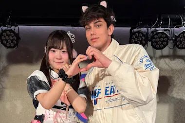 Guest making a heart sign with a maid at a maid cafe