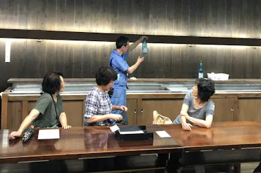 Guests sampling sake at a long brewery tasting counter