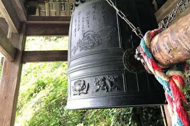 Large bronze bell at a small temple in the woods