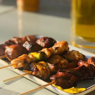 Yakitori and a cold beer. Yakitori skewers beside a glass of beer