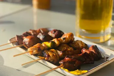 Yakitori skewers beside a glass of beer