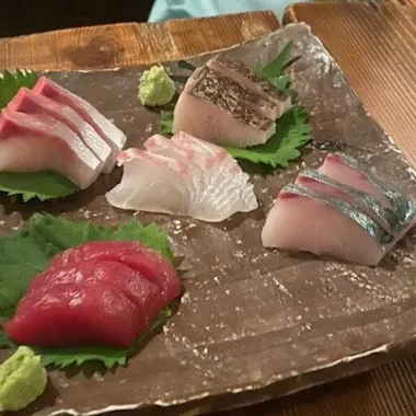 Fresh sashimi to share. Plate of fresh sashimi with wasabi on a wooden board