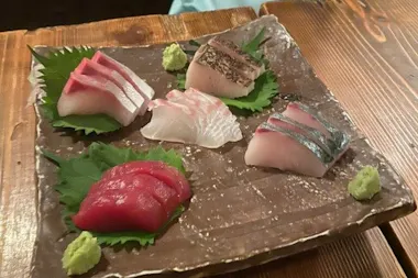 Plate of fresh sashimi with wasabi on a wooden board
