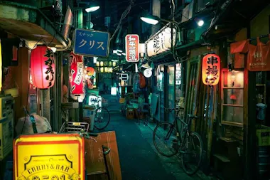 Narrow alley of bars and glowing signs in Sangenjaya at night