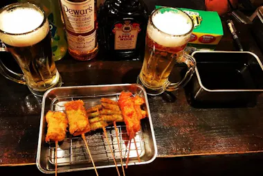 Draft beers and fried kushikatsu skewers on a tray