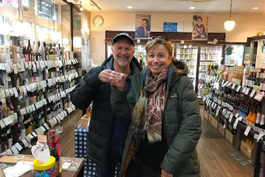 Travelers sipping sake inside a liquor shop in Jujo
