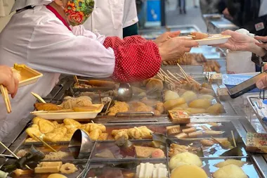 Vendor serving oden from a steaming counter on Sunamachi Ginza