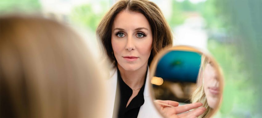 Haley Pena showing a female her reflection in a handheld mirror