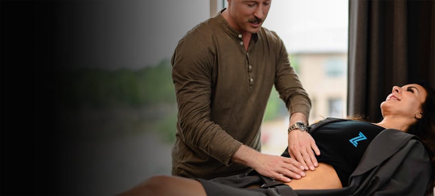 Woman having her abdominal area examined by Dr. Piazza