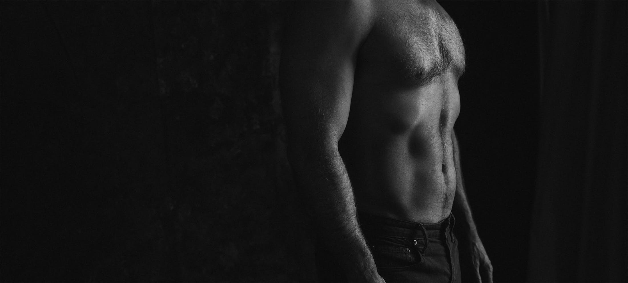 Black and white image of a man's chiseled abs