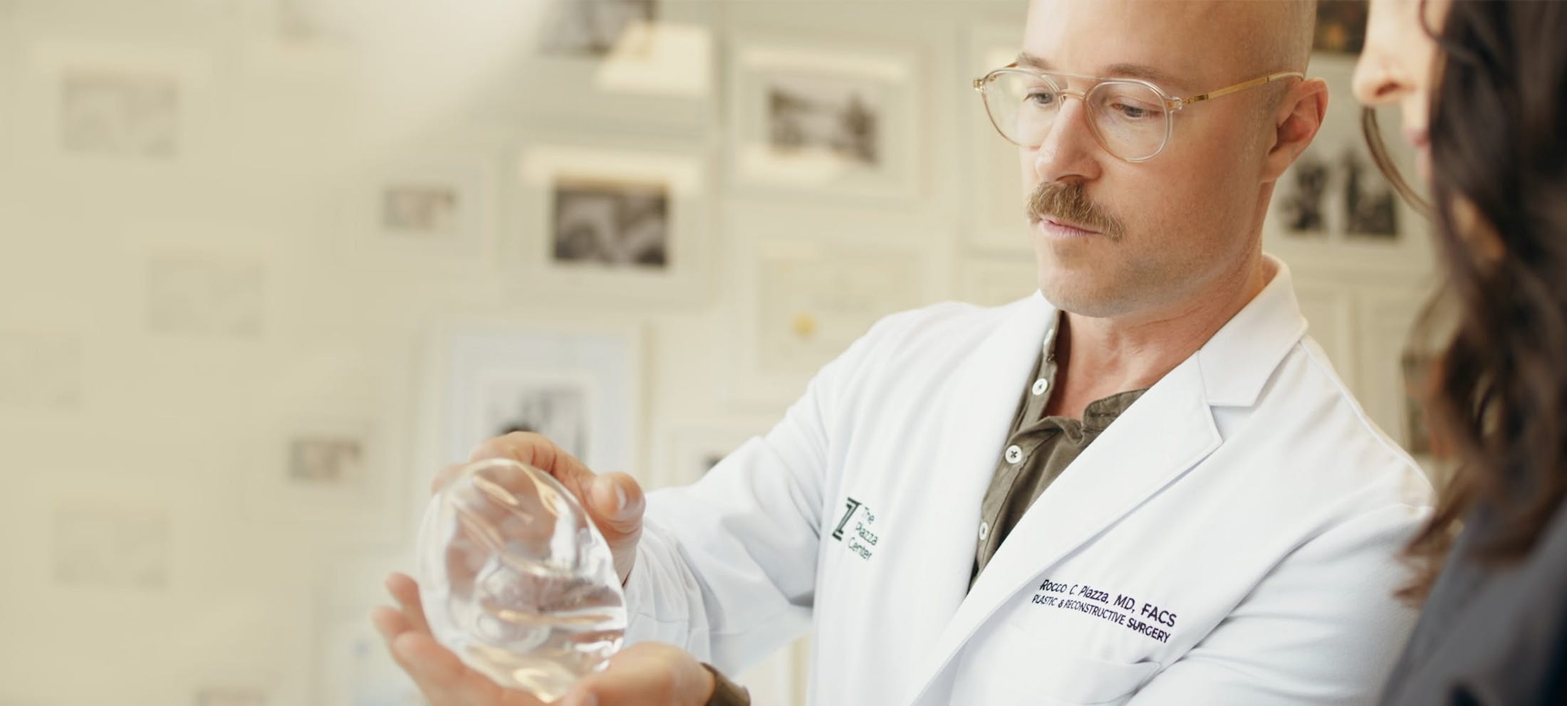 Dr. Piazza looking at a breast implant with a patient