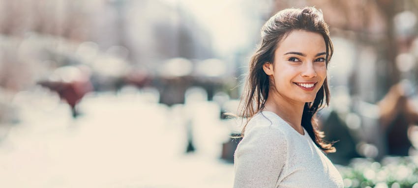Woman with dark hair outside smiling