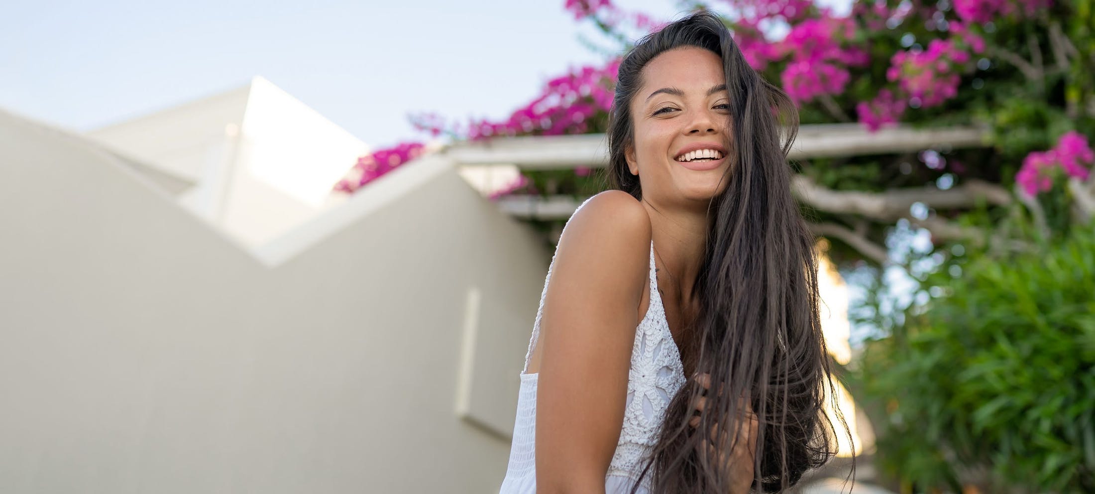 Woman with long dark hair outside smiling