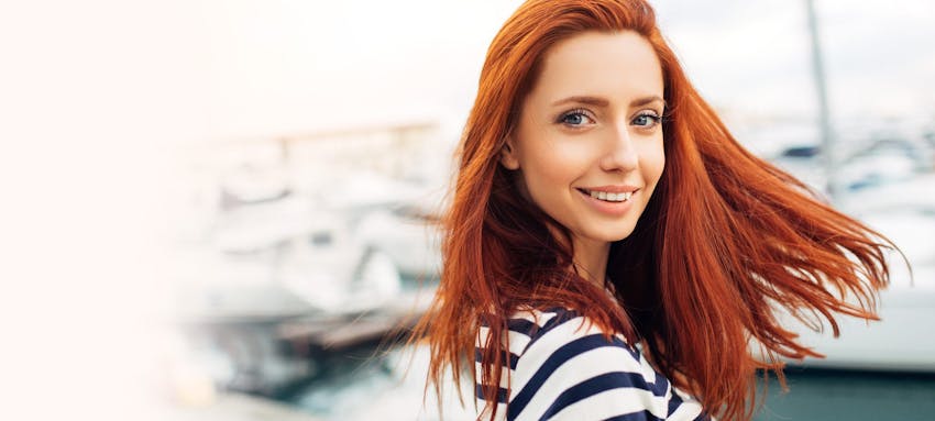 Woman with long red hair outside