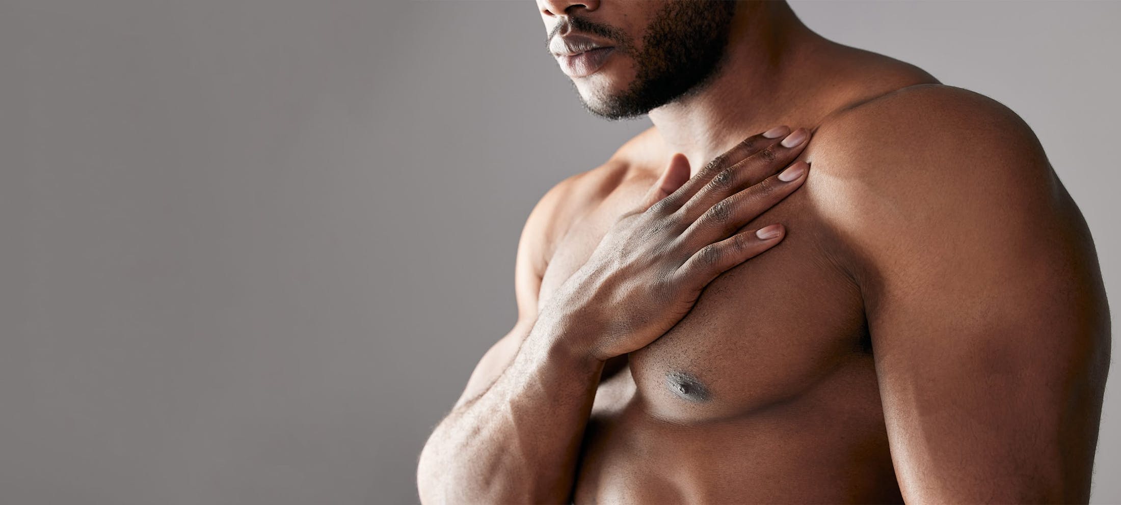 Shirtless man touching his chest