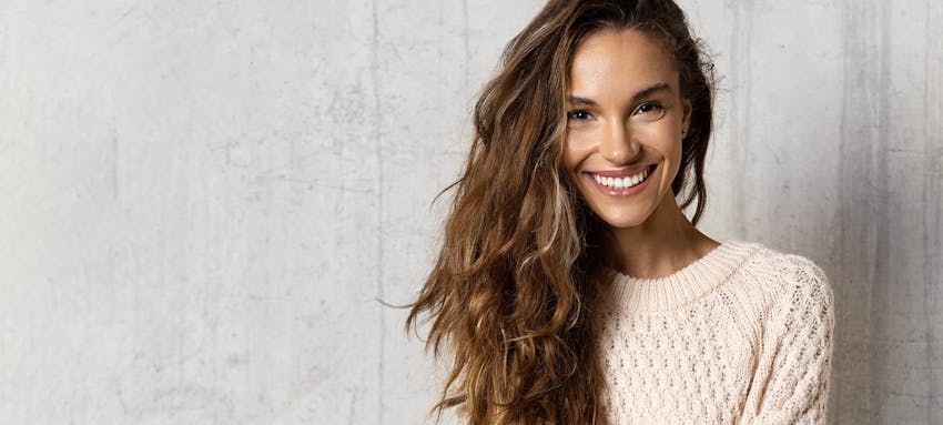 Woman with medium brown wavy hair smiling