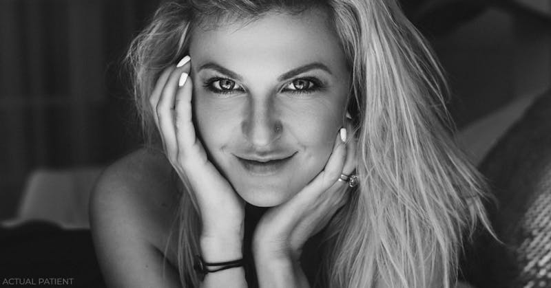 blond woman with long hair and piercings posing for a black and white photo