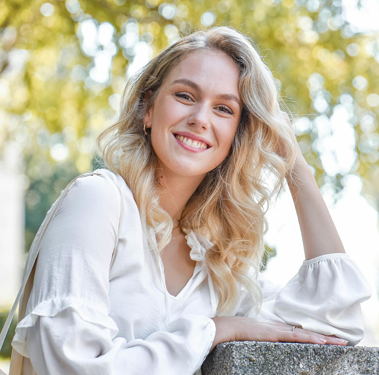 Blonde woman in a white blouse smiling