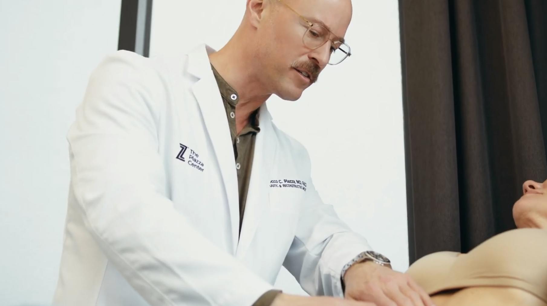 Dr. Piazza examining a female patient's abdominal area