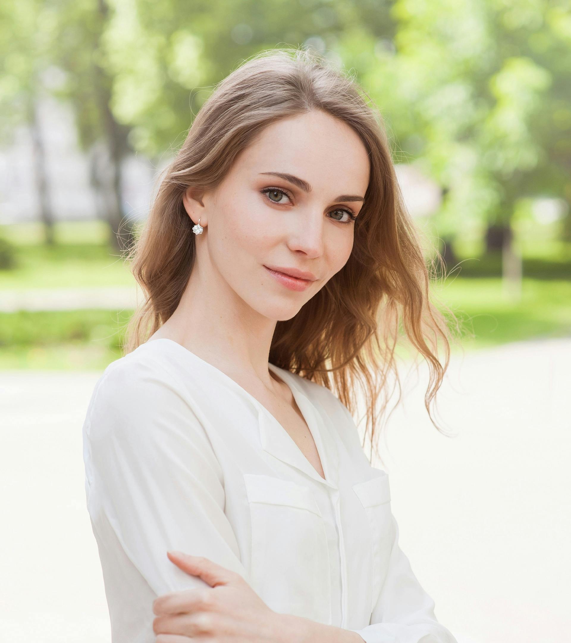 Woman with blonde hair outside wearing a white shirt