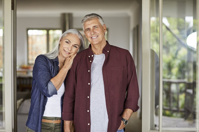 Happy older couple standing side by side smiling