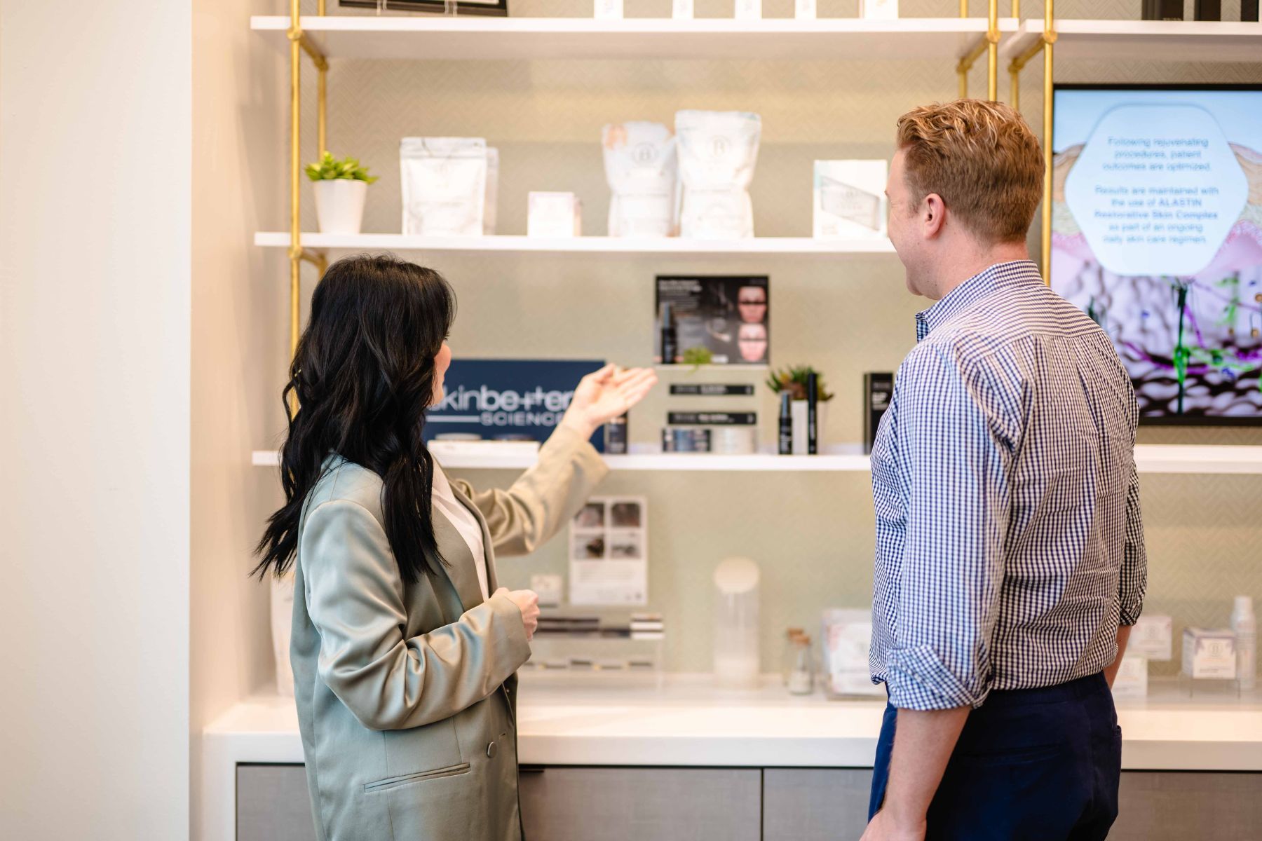 A staff member showing a patient their skincare