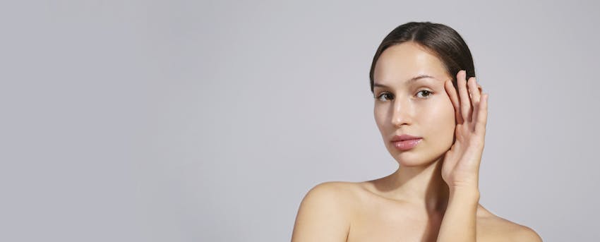 Woman holding her hand up to her face