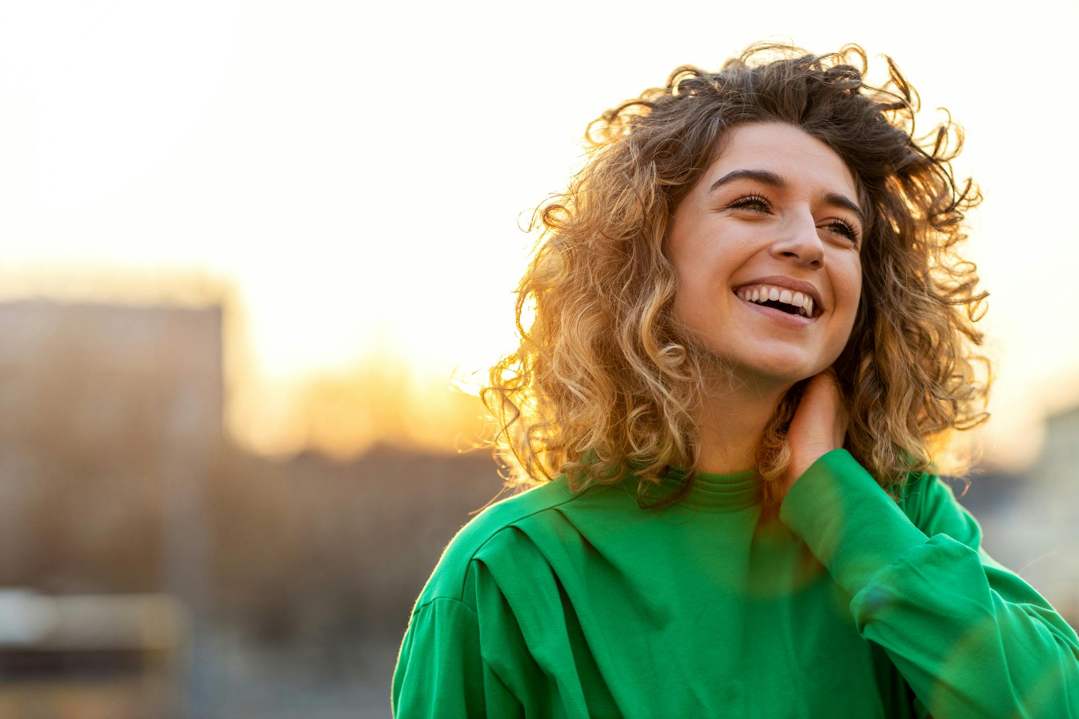 woman holding her neck in a green shirt