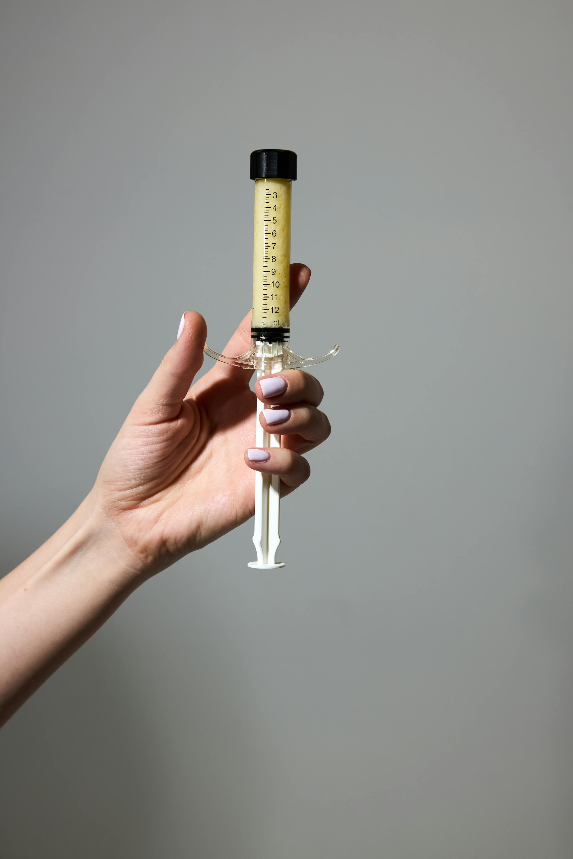hand holding a syringe of AlloClae