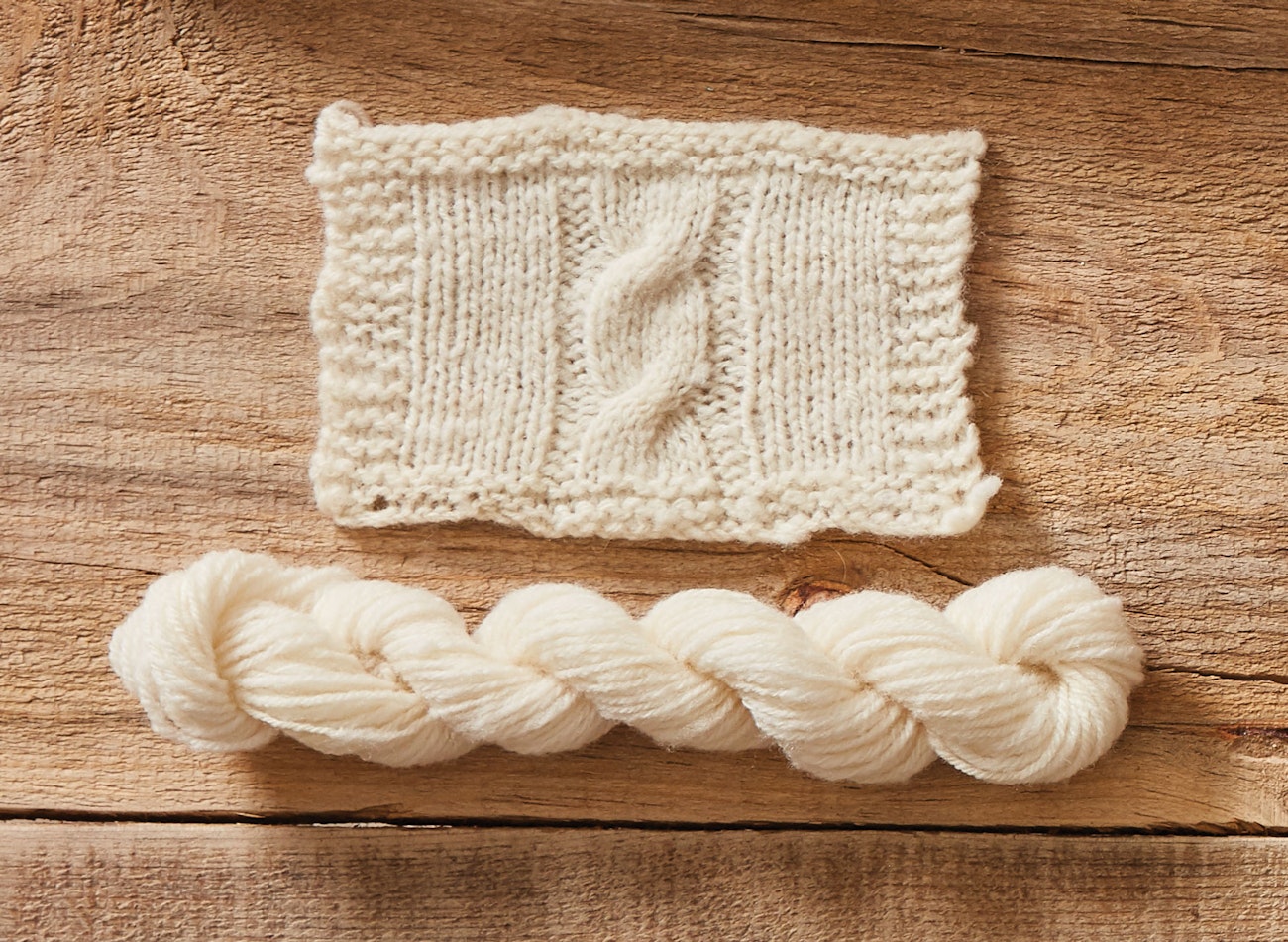 White wool swatch with cable and white handspun twisted skein