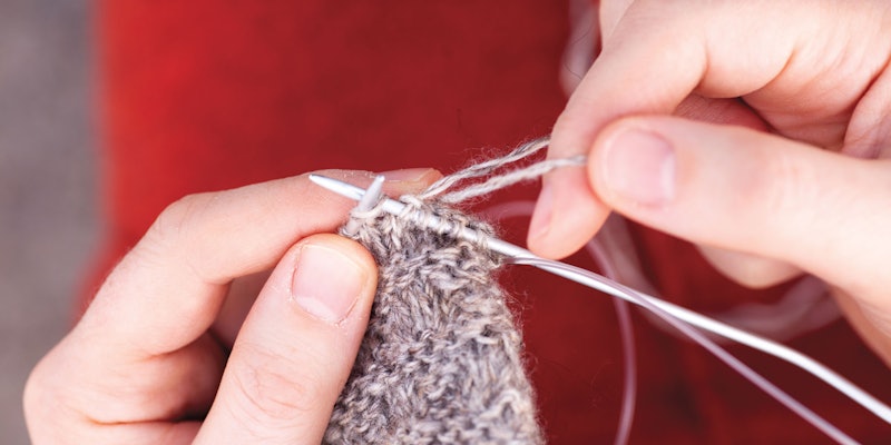 Hands holding knitting needles and working tvåändsstickning