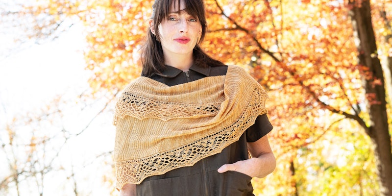 Woman in brown jumpsuit wearing gold lace and garter stitch shawl