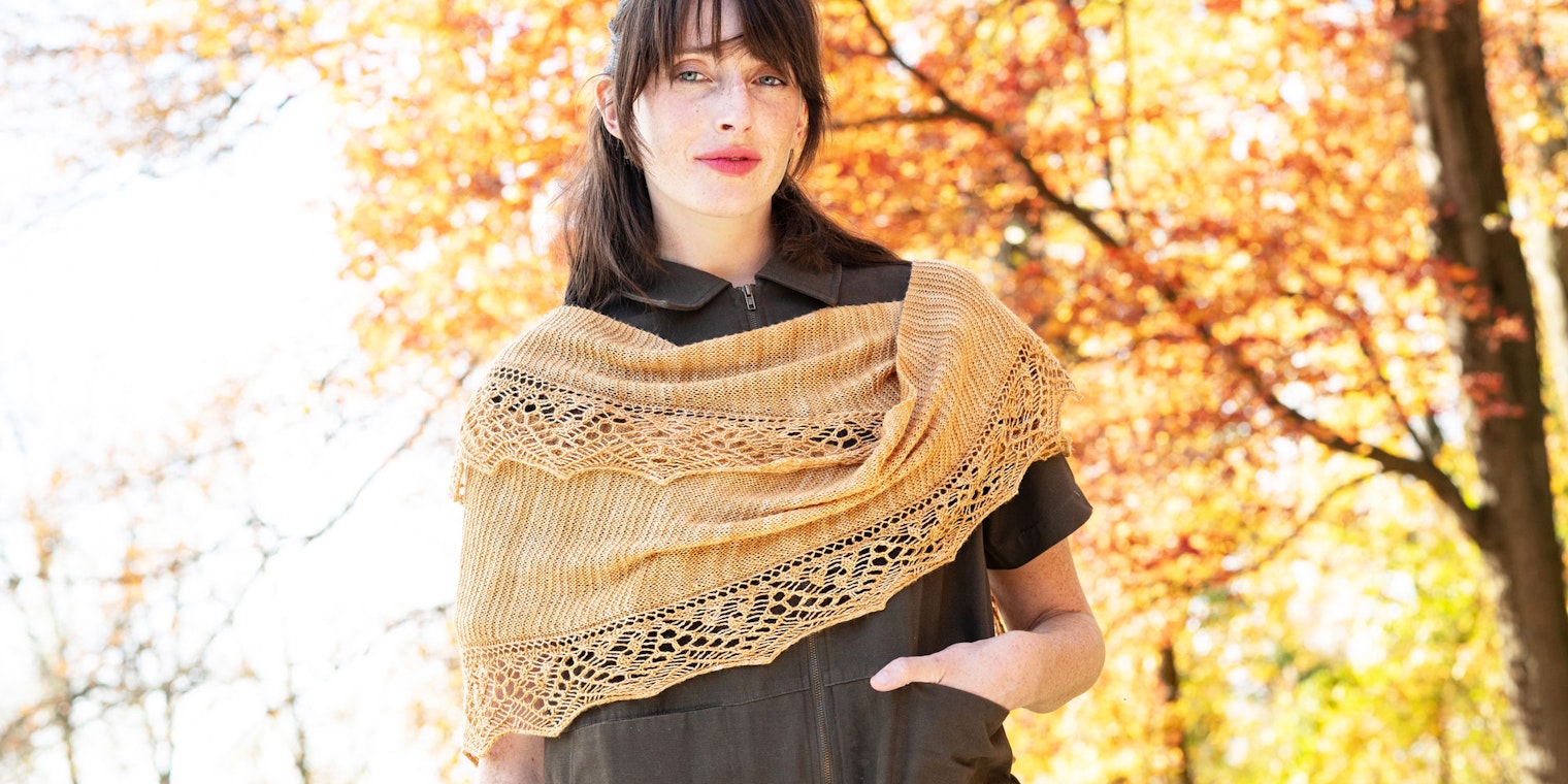 Woman in brown jumpsuit wearing gold lace and garter stitch shawl