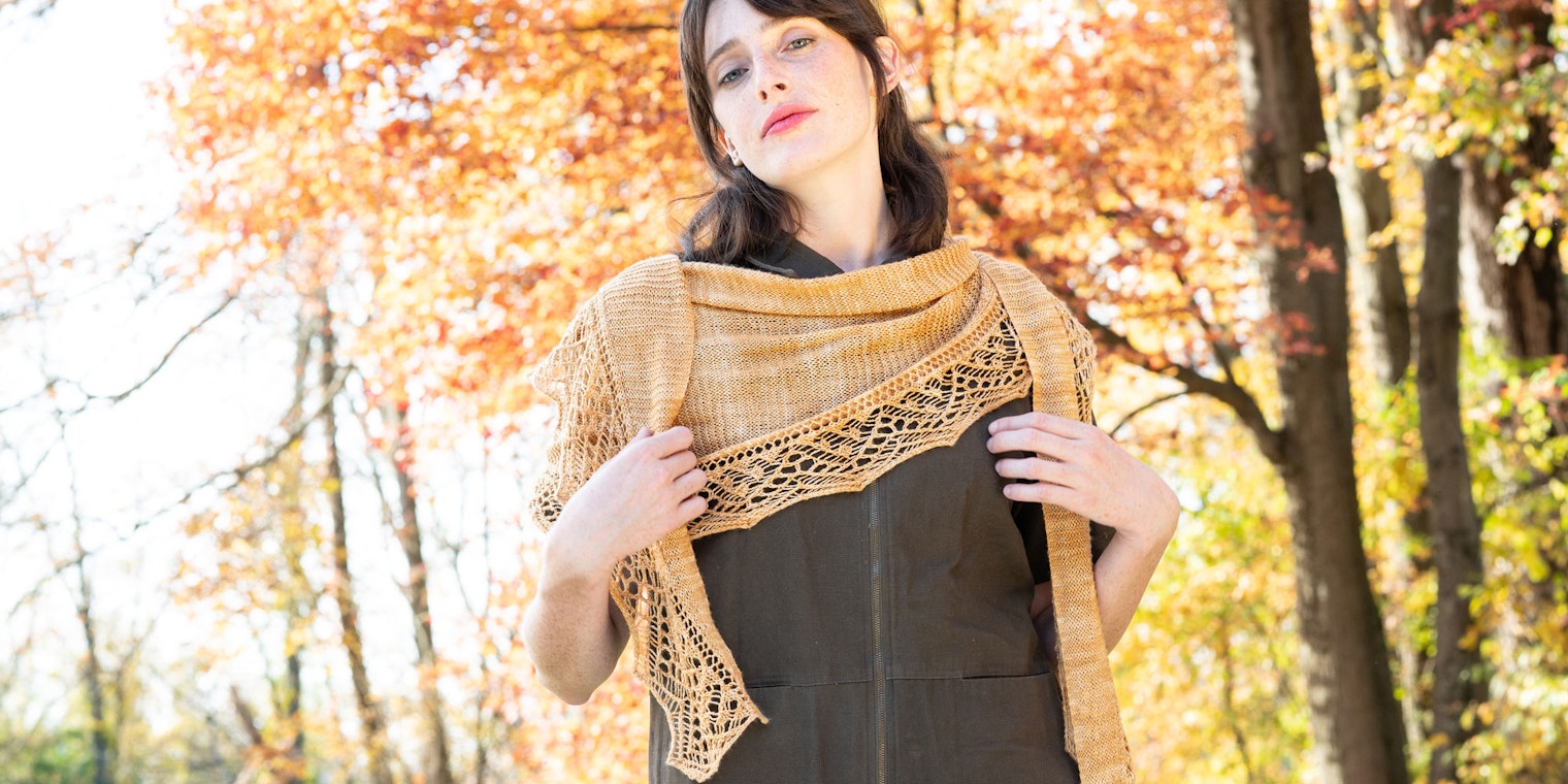Model in brown jumpsuit and gold shawl