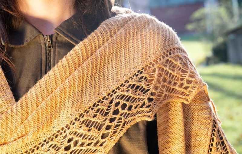 Close-up of lace and garter stitch shawlette draped over shoulder