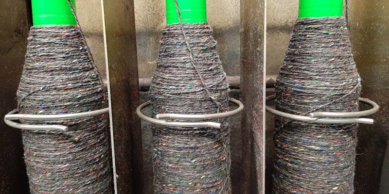 Three spinning bobbins filling with multicolored tweed yarn