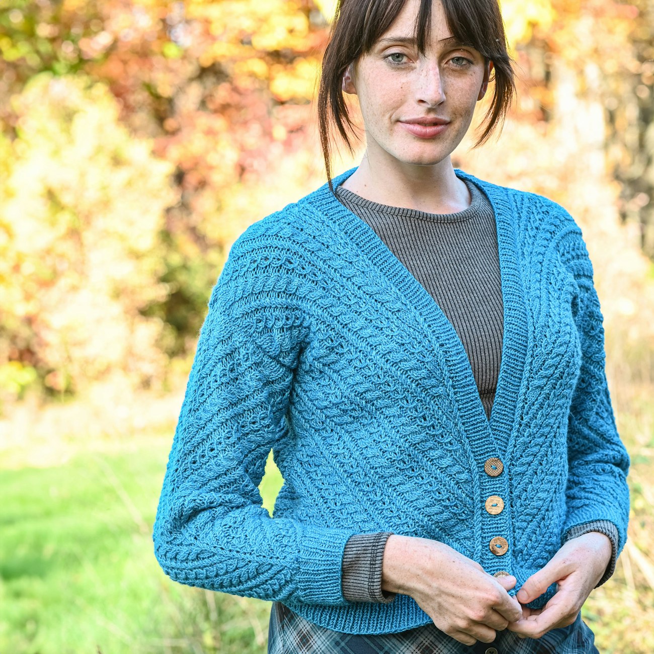 Woman in aqua V-neck cabled cardigan