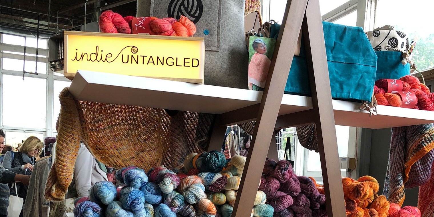 Indie Untangled sign sitting on shelves of yarn