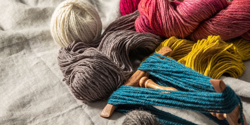 Skeins of colorful yarn on linen background