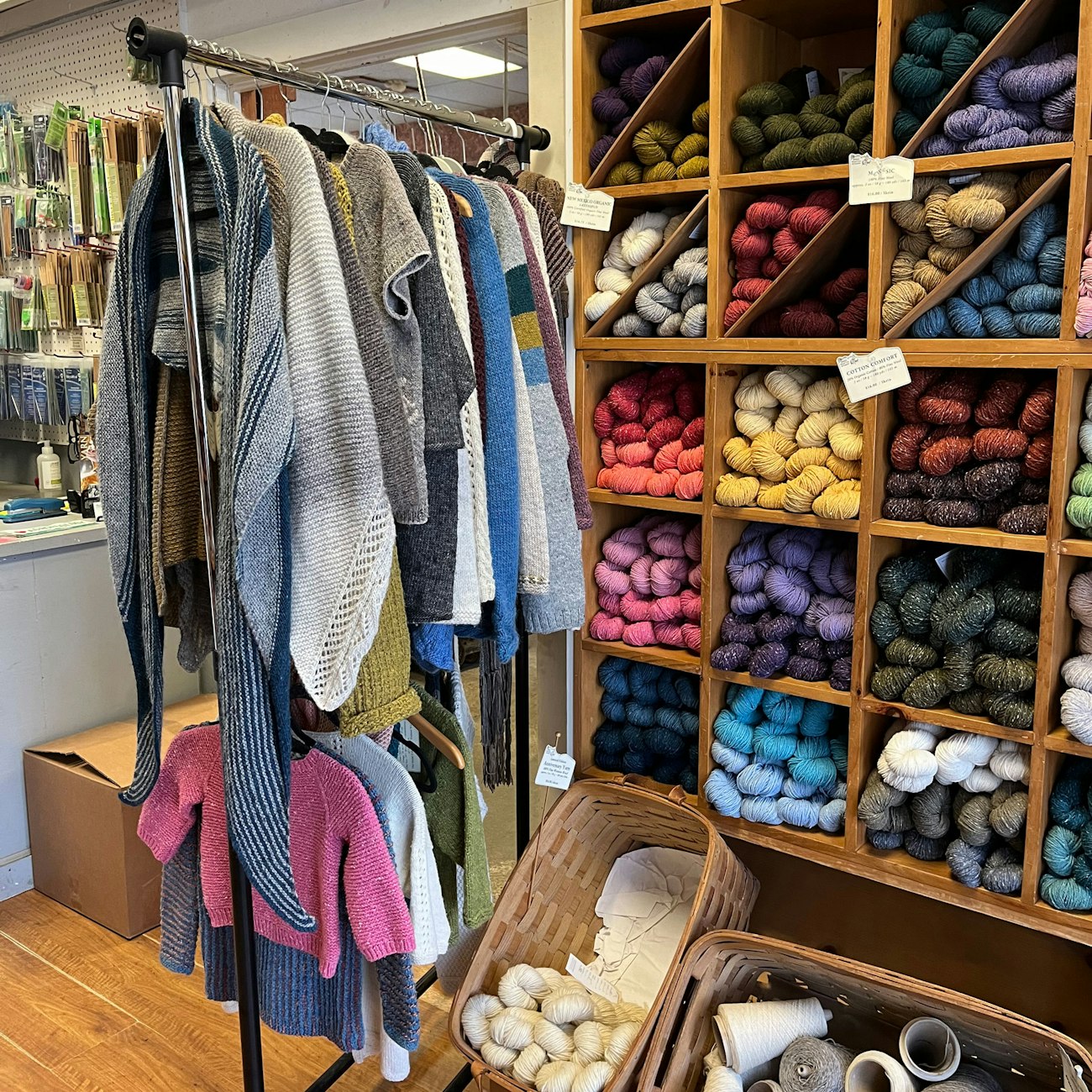 Knitwear on rack, hanks of yarn in cubbies