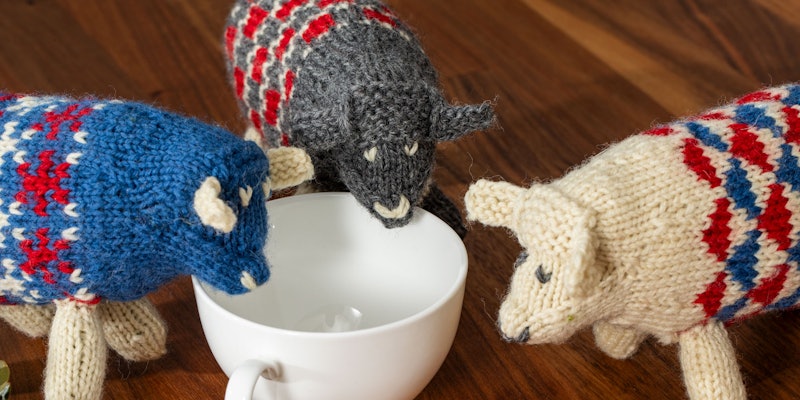 Blue, gray, red, and natural knitted sheep toys
