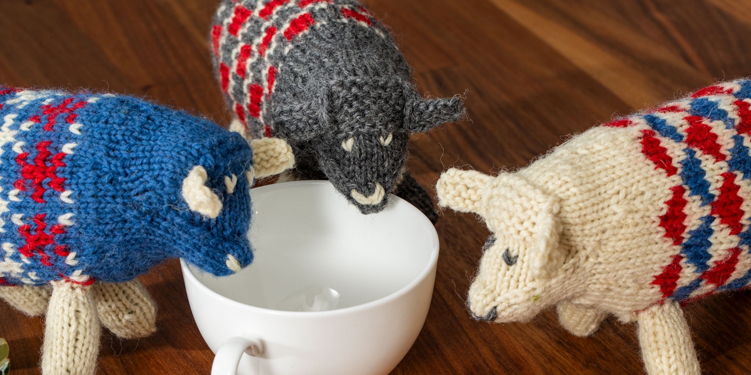 Blue, gray, red, and natural knitted sheep toys