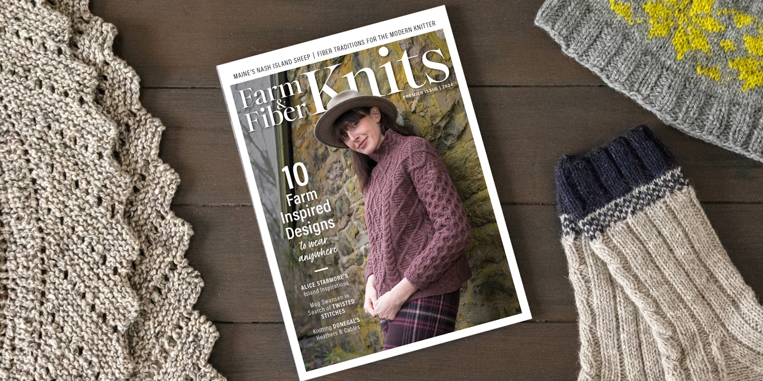 A magazine rests on a table, surrounded by knit items.