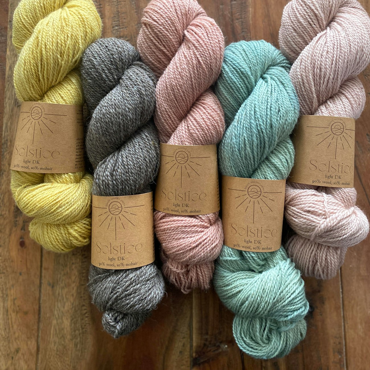 Yellow, gray, peach, aqua, and pink yarns