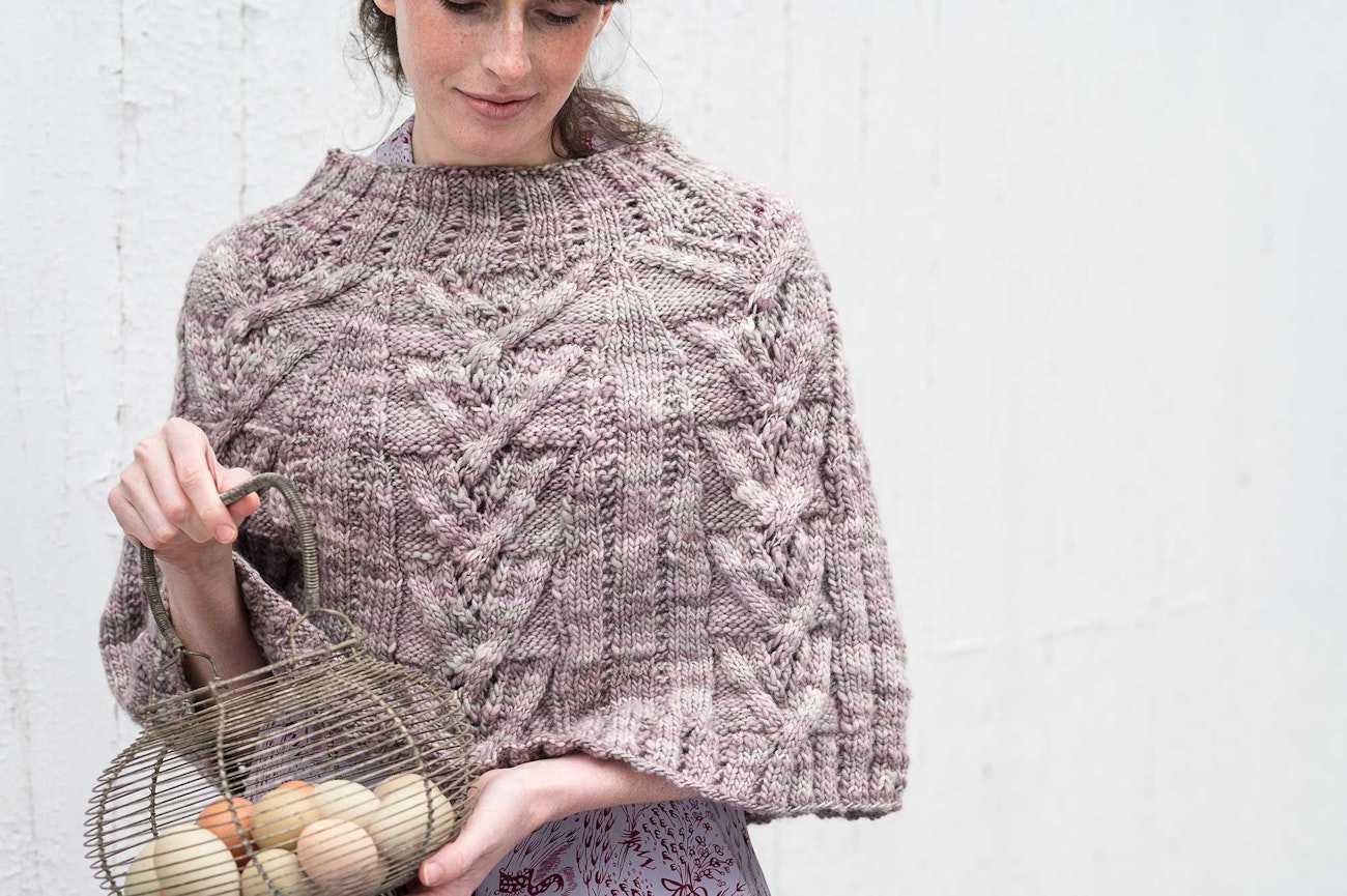 pink knitted poncho with cables