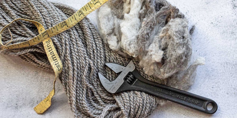 Gray wool and wool yarn are shown with a yellow tape measure and metal wrench.