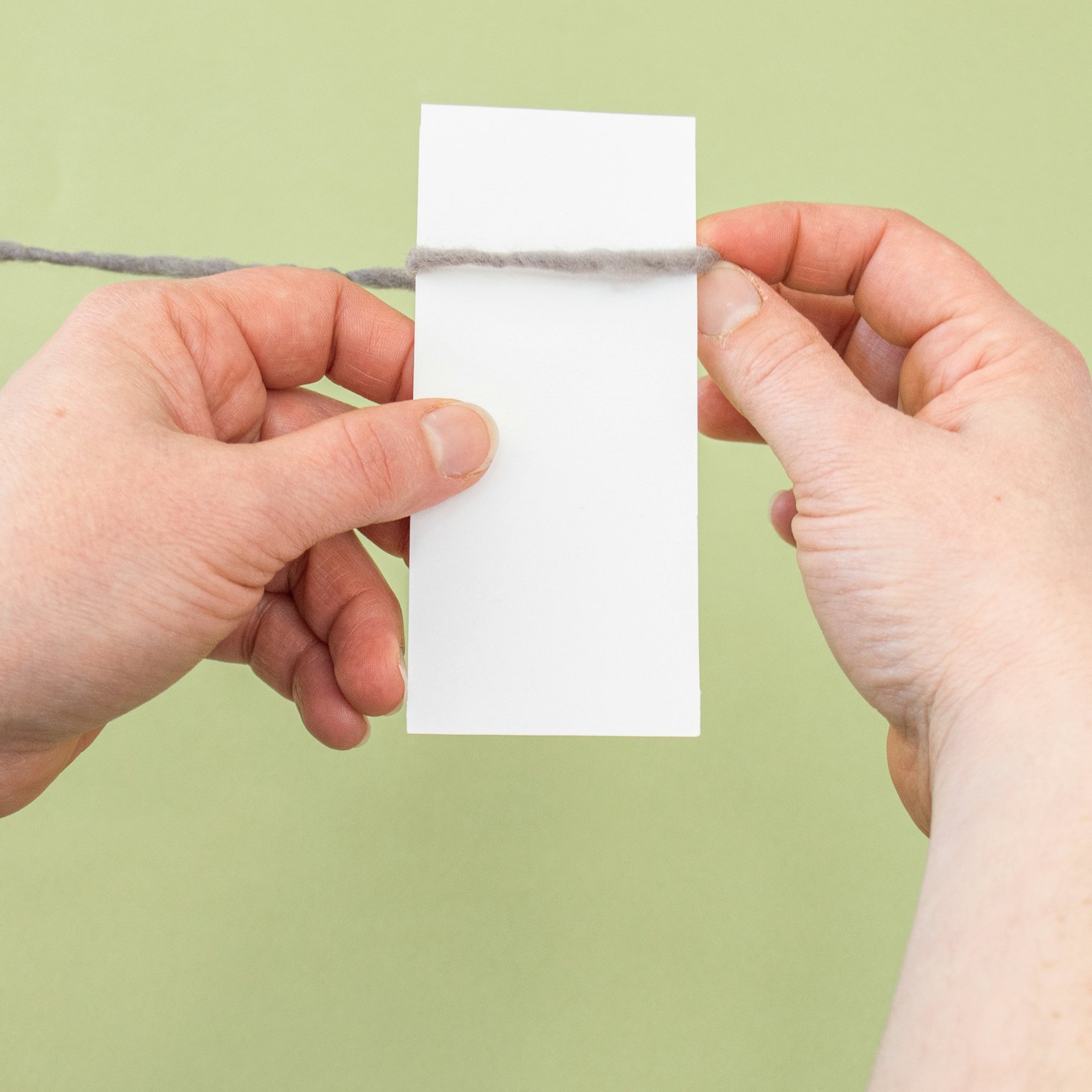 Tape one end of yarn to the back of the card and begin wrapping. Photo by Pamela K. Schultz