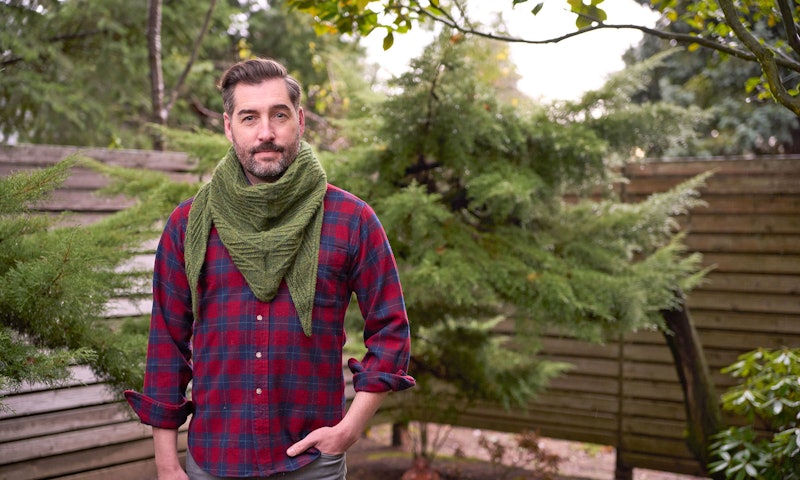 man in plaid shirt wearing green scarf