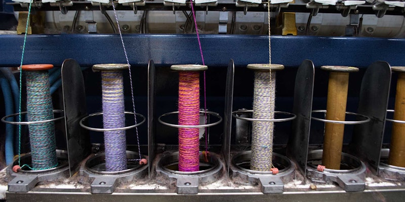 Colorful yarn on a plying machine at a mill.